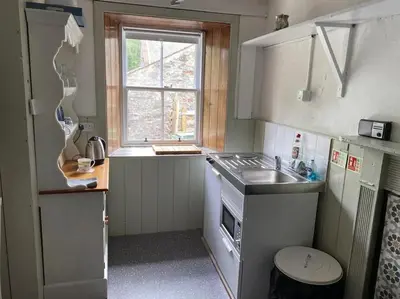a small kitchen with a sink and a window at The Bothy at Christmas Cottage in Rowardennan