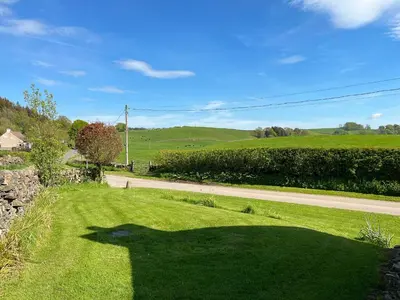 a shadow of a person on a field of grass at Kilquhanity Cottage in Castle Douglas