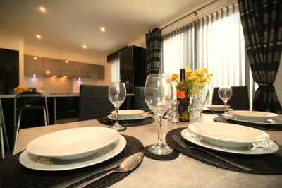 a dining room table with plates and wine glasses at Signature - Oatlands House in Glasgow