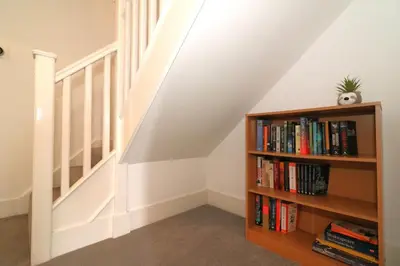 a staircase with a book shelf with books at Signature - Oatlands House in Glasgow
