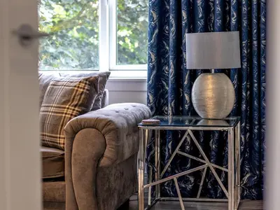 a living room with a chair and a lamp on a table at Renfrew Town Centre Easy Link to Glasgow City - Pass the Keys in Renfrew
