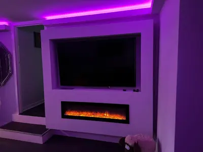 a living room with a fireplace with a tv at The Schoolhouse Largs in Largs