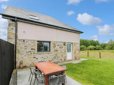 a stone cottage with a picnic table in front of it at The Barn, Drumbow Farm in Airdrie