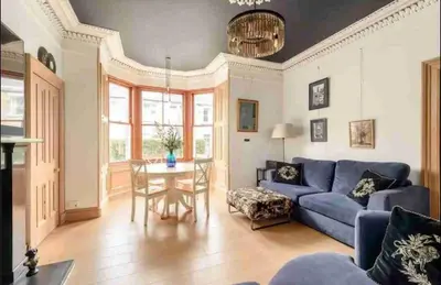 a living room with a blue couch and a table at amazing apartments - Avondale Pl by Stockbridge in Edinburgh