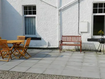 a patio with a table and chairs and a bench at Goatfell View in Brodick