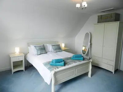 a bedroom with a bed with two blue towels on it at Craegard House in Corrie