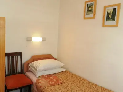 a small room with a bed and a chair at Hamilton Terrace in Lamlash