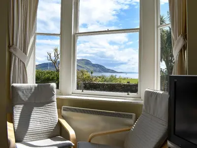 a room with two chairs and a large window at Hamilton Terrace in Lamlash