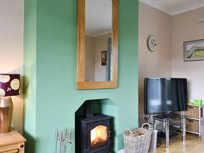 a living room with a fireplace and a television at Fellview in Brodick