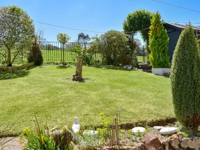 a garden with a yard with a fence at Fellview in Brodick