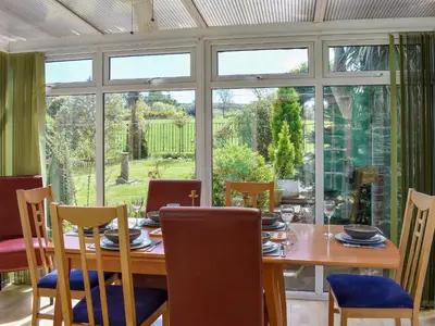 a dining room with a table and chairs and a large window at Fellview in Brodick