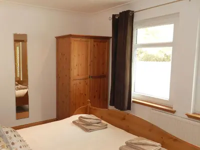 a bedroom with a bed and a window at Glen Rosa Lodge in Brodick