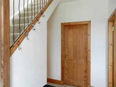 a stairwell with a wooden door and a stair railing at Torbeg Farm Cottage in Torbeg