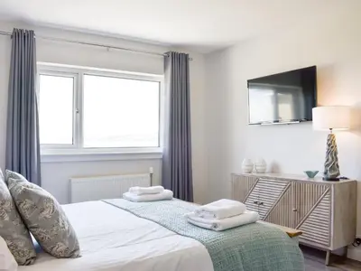 a bedroom with a bed with two towels on it at Kinneil Land in Lamlash