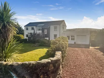 a house with a stone fence in front of it at Hollinhaven in Blackwaterfoot