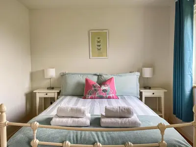 a bedroom with a bed with pink pillows at Hollinhaven in Blackwaterfoot