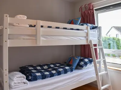two bunk beds in a room with a window at Hollinhaven in Blackwaterfoot