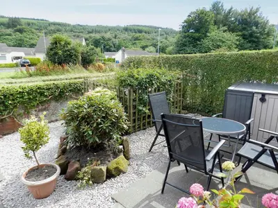 a patio with a table and chairs and plants at Sunnyside Cottage in Lamlash