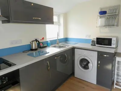 a kitchen with a sink and a washing machine at Sunnyside Cottage in Lamlash