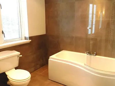 a bathroom with a tub and a toilet and a sink at St Brides in Lamlash