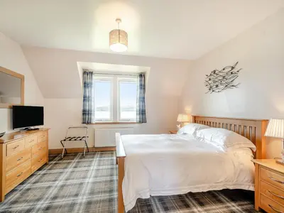 a bedroom with a bed and a flat screen tv at Sky View in Ardmaleish