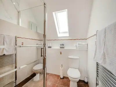 a white bathroom with a toilet and a shower at Sky View in Ardmaleish