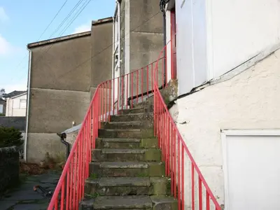 a staircase with a red fence next to a building at Apartment Sea View in Hunters Quay