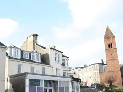a tiny house is parked in front of a building at Apartment Sea View in Hunters Quay