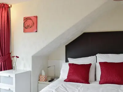 a bedroom with a bed with red pillows at Apartment Sea View in Hunters Quay