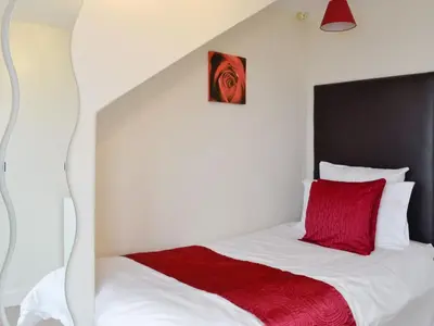 a bedroom with a bed with a red pillow at Apartment Sea View in Hunters Quay