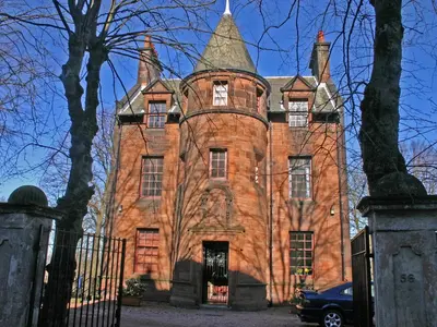an old red brick building with a tower at Brough Hall in Paisley