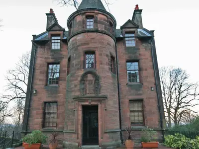 an old red brick building with a tower at Brough Hall in Paisley