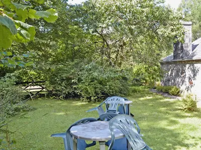 two chairs and a table in a yard at Squirrel Cottage in Palnure