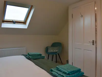 a bedroom with a bed and a window and a chair at Park House in Blackwaterfoot
