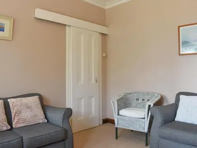 a living room with two chairs and a chair and a couch at Redhurst Cottage in Lamlash