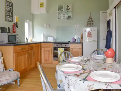 a kitchen with a table with plates on it at Redhurst Cottage in Lamlash