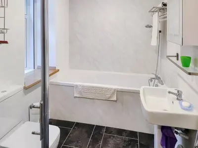 a bathroom with a white tub and a sink at Old Steading in Brodick
