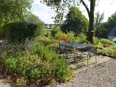 a table and chairs in the middle of a garden at Old Steading in Brodick