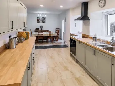 a kitchen with wooden counter tops and a dining room at Old Steading in Brodick