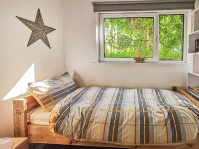 a bedroom with a bed and a window at An Cala in Brodick