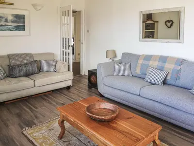 a living room with two couches and a coffee table at An Cala in Brodick