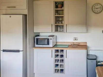 a kitchen with a microwave on a counter next to a refrigerator at An Cala in Brodick