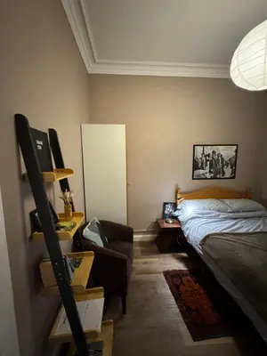 a bedroom with a bed and a desk with a chair at Central Room In Historic Tenement Shared Apartment Near Old Town in Edinburgh