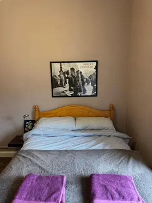 a bedroom with a bed with purple mats on it at Central Room In Historic Tenement Shared Apartment Near Old Town in Edinburgh