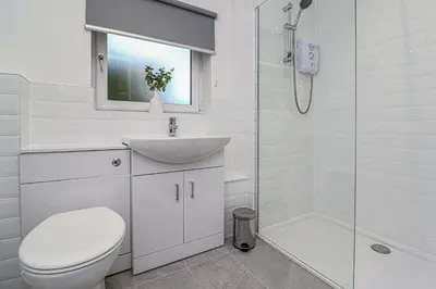 a bathroom with a toilet and a sink and a shower at Wyndford Riverside House in Glasgow