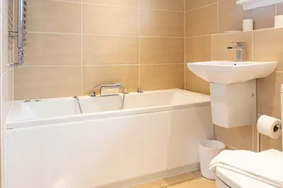a bathroom with a sink and a bath tub at Moncrieff House in Livingston