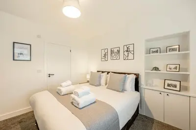 a bedroom with a white bed with two pillows on it at Cowden Coorie in Fife