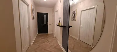 a hallway with a mirror and a black door at The Old Courthouse in Rothesay