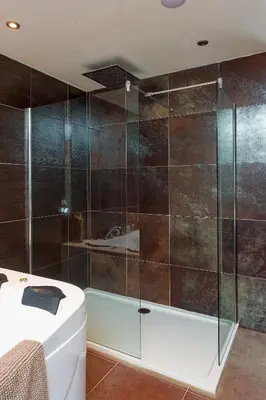 a bathroom with a glass shower with a tub at Brig O'Doon 1 in Ayr