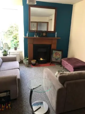 a living room with a couch and a fireplace at House in Drymen Village with free local health club access in Glasgow